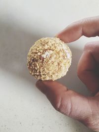 Cropped image of hand holding dessert on table