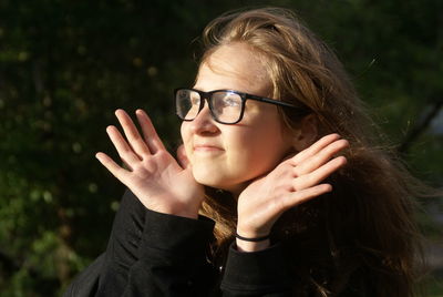 Thoughtful woman gesturing on sunny day