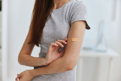 Midsection of woman holding hands while standing at home