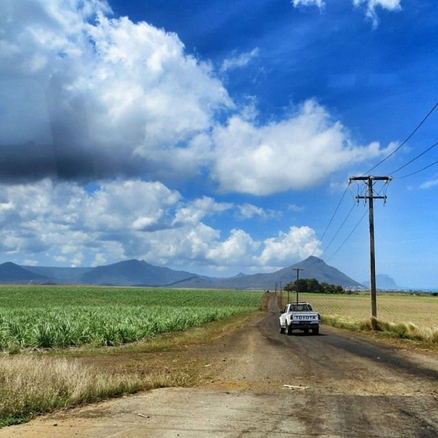 transportation, land vehicle, sky, mode of transport, car, road, electricity pylon, cloud - sky, power line, mountain, the way forward, on the move, cloud, landscape, cloudy, electricity, country road, diminishing perspective, travel, power supply