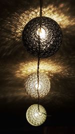 Low angle view of illuminated chandelier hanging on ceiling