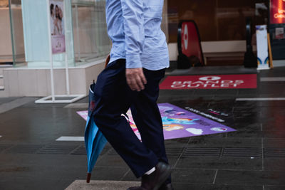 Low section of man standing on street in city