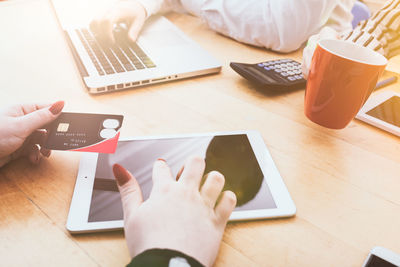 Midsection of man using laptop on table