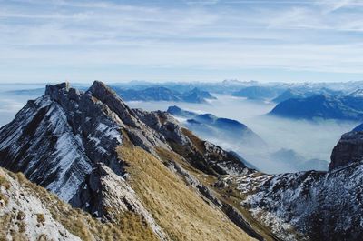 Scenic view of mountains against cloudy sky