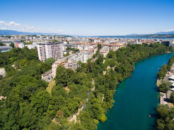 High angle view of buildings and trees against blue sky