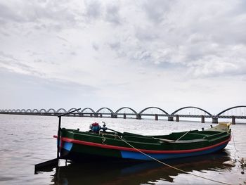 Boats moored on river against sky