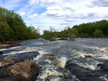 Scenic view of river against cloudy sky