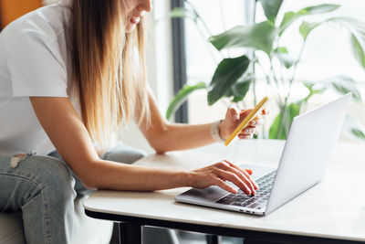 Midsection of woman using laptop at office