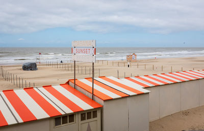 Scenic view of beach huts on a deserted beach against sky