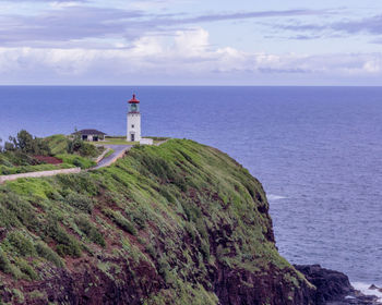 Lighthouse by sea against sky