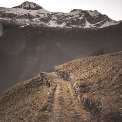 Scenic view of a mountain path against snowcapped mountains 