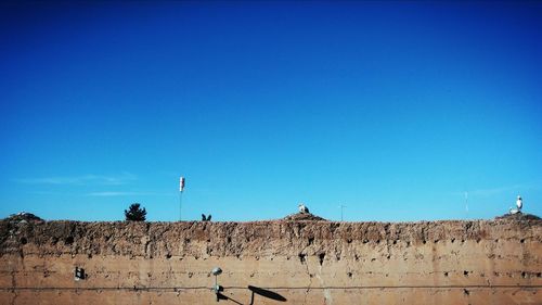 Panoramic view of people on mountain against blue sky