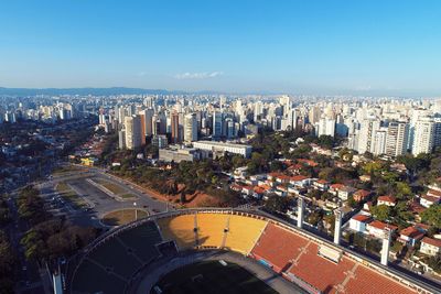 High angle view of buildings in city against blue sky