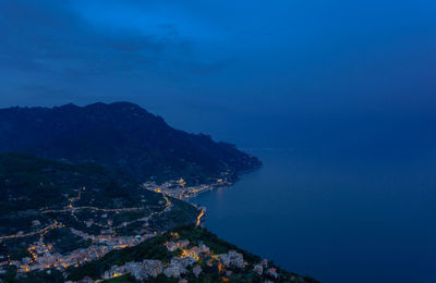 High angle view of sea by mountains against sky