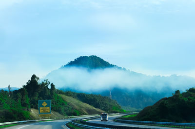 Road leading towards mountains against sky