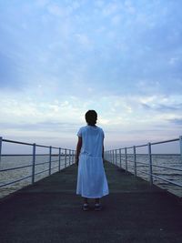 Rear view of woman looking at sea against sky