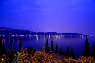 Scenic view of lake against clear blue sky at night