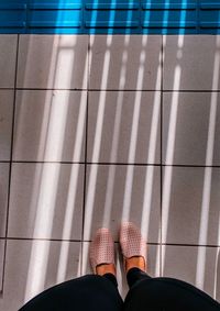 Low section of person standing on tiled floor