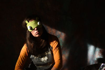 Woman wearing sleep mask at home