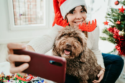 Midsection of woman with dog at home