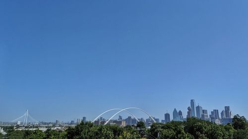 View of buildings in city against blue sky