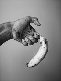 Midsection of person holding ice cream against white background