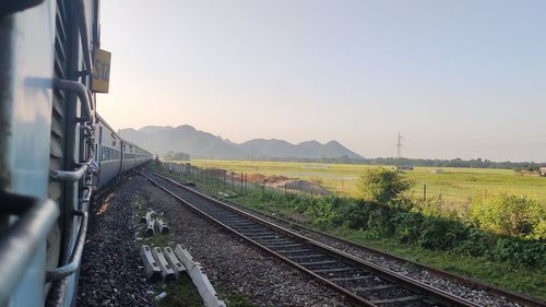 Railroad track amidst field against clear sky