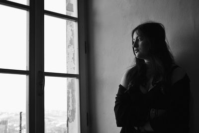 Woman looking away while standing at home