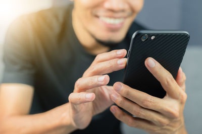 Midsection of man using mobile phone