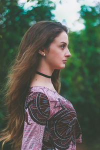 Young woman standing against tree