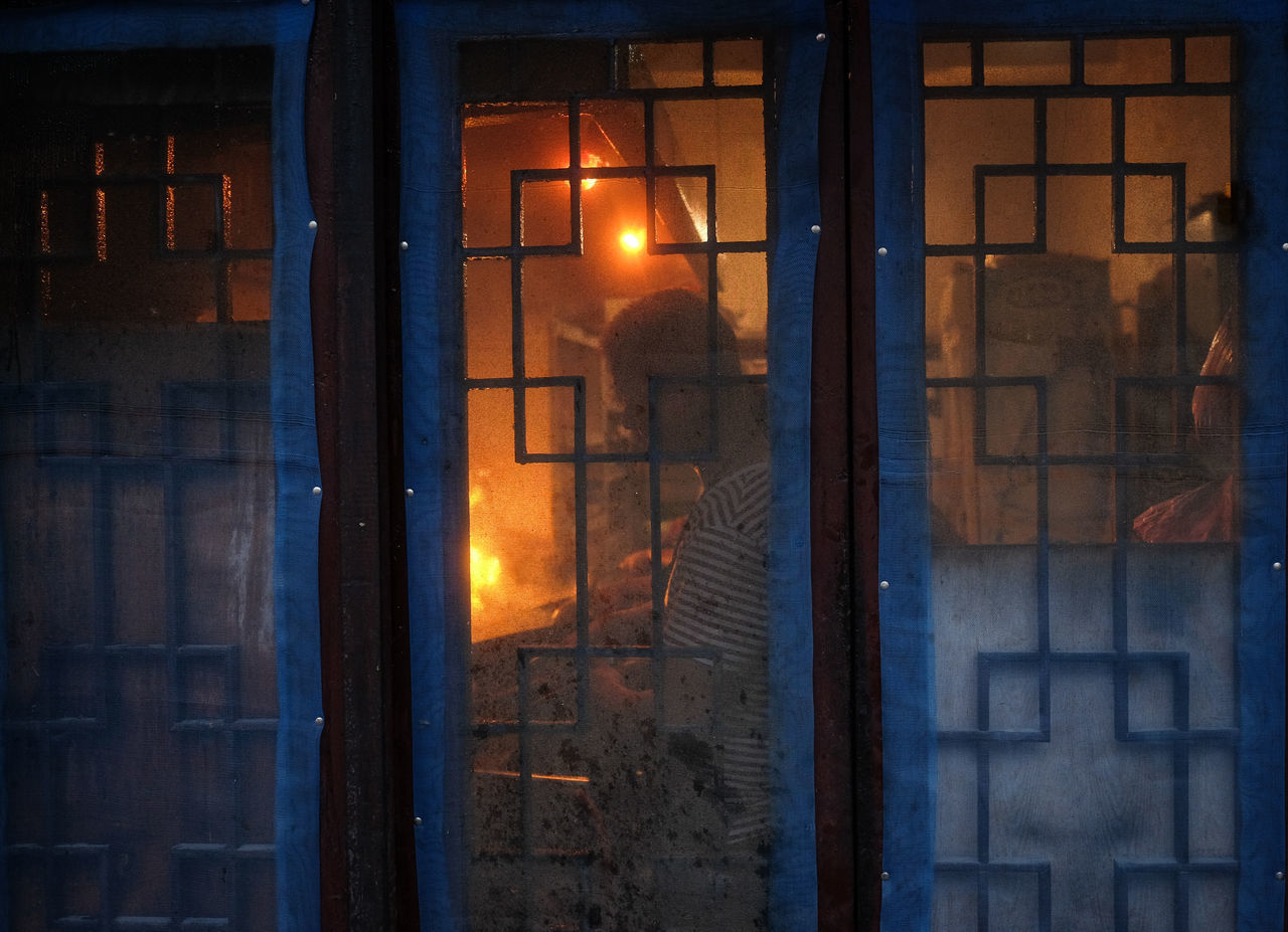 BUILDINGS SEEN THROUGH GLASS WINDOW AT NIGHT