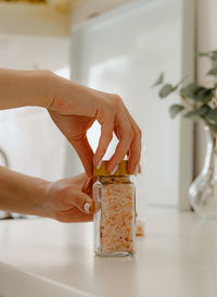The girl closes the lid on a jar of spices.