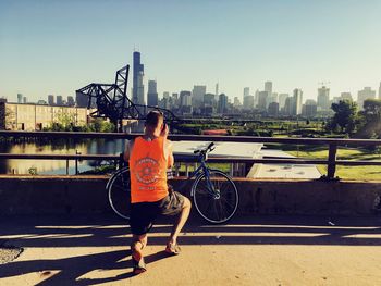 Full length of woman standing by cityscape against sky