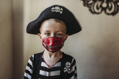 Portrait of school age young boy dressed as pirate with face mask on