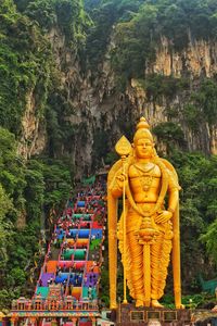 Buddha statue by trees against mountain