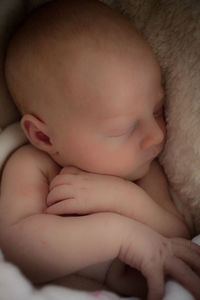 Close-up of baby sleeping in bed