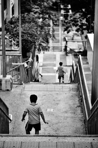 Rear view of men walking on footpath