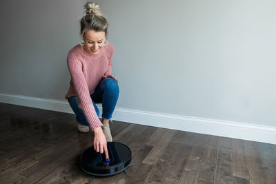 Young woman looking down while sitting on floor at home