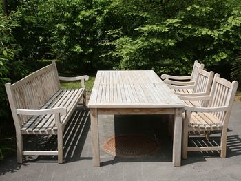 Empty chairs and table against trees