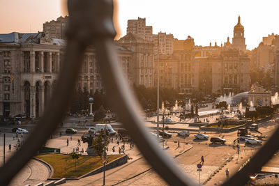 Beautiful silhouette of kyiv cityscape through metal frame during sunset