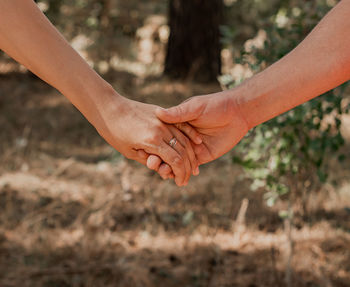 Midsection of couple holding hands