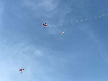 Low angle view of kite flying against blue sky