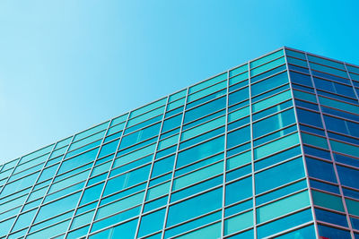 Low angle view of modern building against clear blue sky