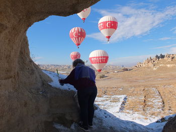 Hot air balloons on rock against sky