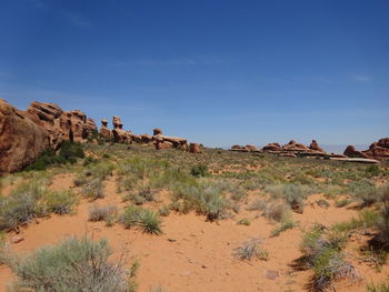 Rock formations on desert land against sky
