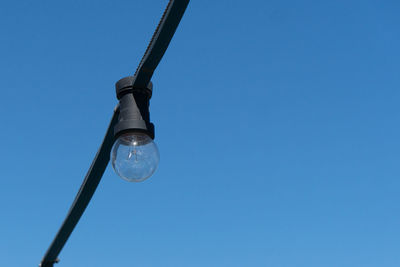 Close up of string light against blue summer sky