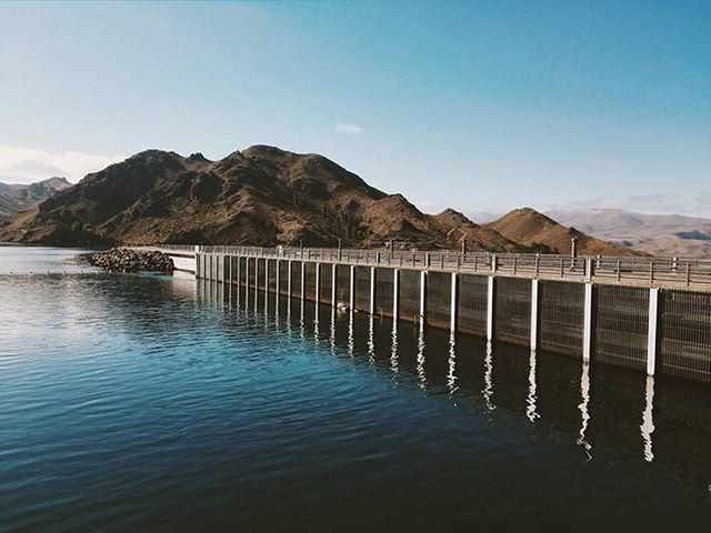 mountain, water, mountain range, tranquil scene, waterfront, tranquility, built structure, scenics, lake, sky, beauty in nature, pier, architecture, sea, nature, reflection, blue, rippled, idyllic, day