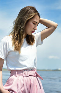 Beautiful young woman standing in sea