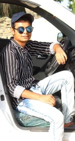 Young man sitting in car