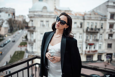 Woman standing against railing in city